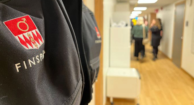 På rundvandring i hemtjänstens korridor. I förgrunden hänger en svart väska med Finspångs kommuns logotype.